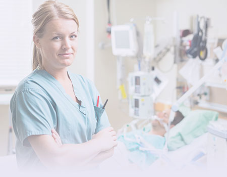 Blond female nurse standing in front of patient in ICU bed for critical care continuing education courses for nursing