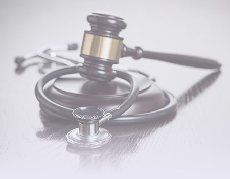 Dark-wood and gold gavel laying on top of black stethoscope representing nursing  CEUs on ethics and legal issues