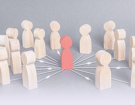 Red wooden figure surrounded by plain wooden figures representing leadership and management nursing CEUs