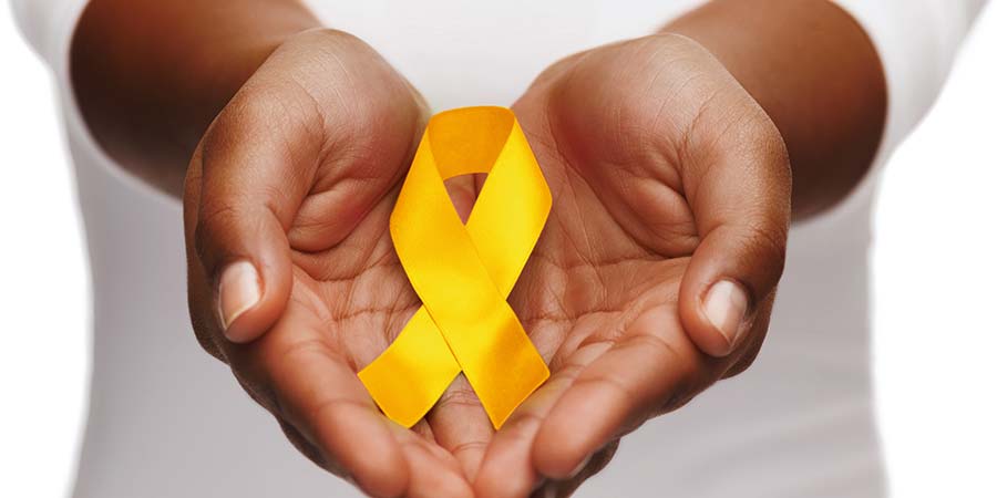 Two hands pointing towards viewer, holding yellow ribbon representing suicide prevention