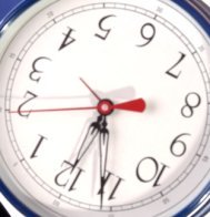 A clock with its hands at five minutes to midnight.