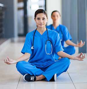 Nurses sitting on floor meditating