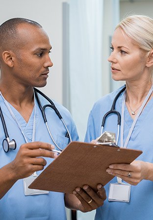 Two nurses discussing a patients chart