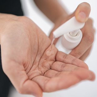 Using hand sanitizer to clean your hands.
