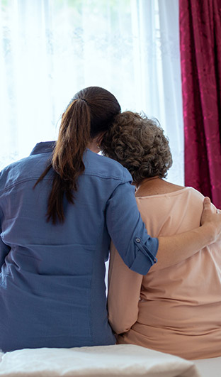 Caregiver and patient hugging each other.