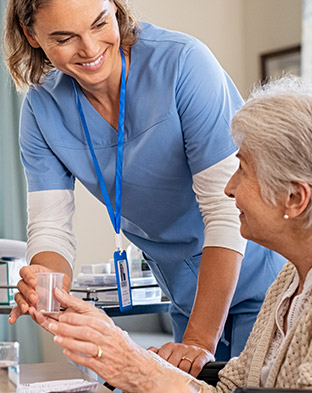 Nurse Helping a group of elderly patients at a table.