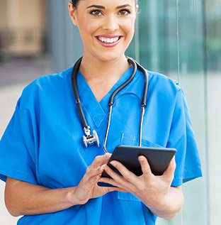 Nurse reviews her tablet.