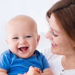 Baby laughing in moms arms