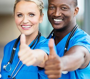 Two nurses giving the thumbs up sign