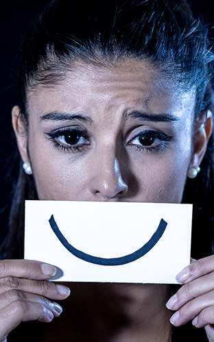 A depressed lady faking a smile