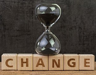 An hourglass on top of word blocks spelling change