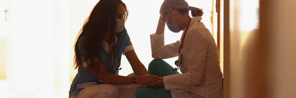 One nurse calming her stressed co-worker.