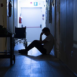 nurse sitting in a dark corridor