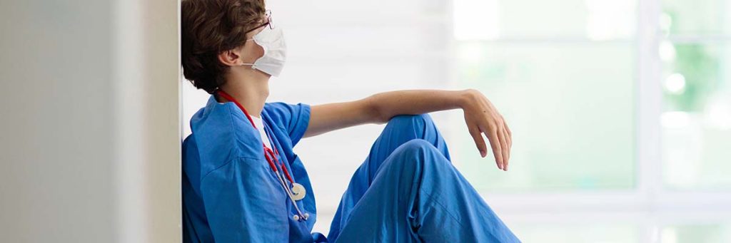 A nurse with burnout collapses in the corridor for a quick breather.