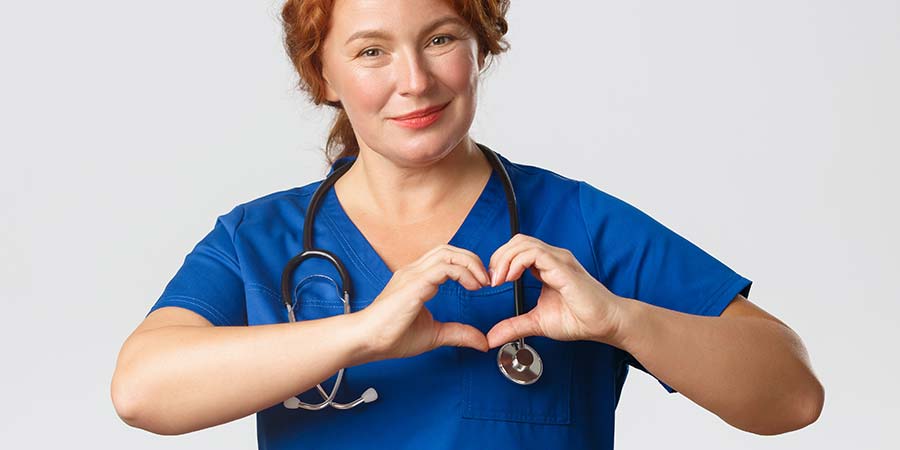 Nurse forming a heart shape with her two hands.