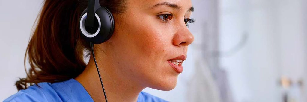 Close up of a nurse wearing headphones, listening to a nursing audio course and studying nursing ceu.