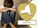 Young abused child sitting crosslegged on floor with head in crossed arms and New York state outline