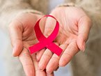 Two hands pointing towards viewer, holding red ribbon representing HIV/AIDS prevention