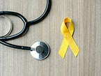 Yellow ribbon representing suicide awareness and prevention next to black stethoscope on table
