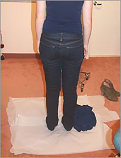 Forensic examination clothing collection photo showing patient disrobing on floor covering.