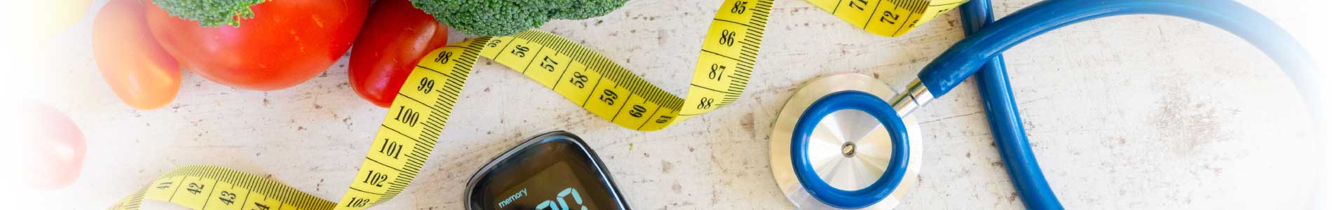 Broccoli, small tomatoes, a blue stethoscope, a tape measure and metabolic syndrome testing device laying on white surface