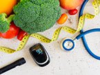 Broccoli, small tomatoes, a blue stethoscope, a tape measure and metabolic syndrome testing device laying on white surface