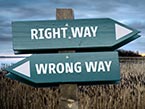 A wooden sign with two directional labels pointing in opposite directions, one saying Right Way and the other Wrong Way