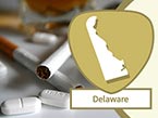 White pills and filter cigarettes laying on white surface for substance abuse and Delaware state outline