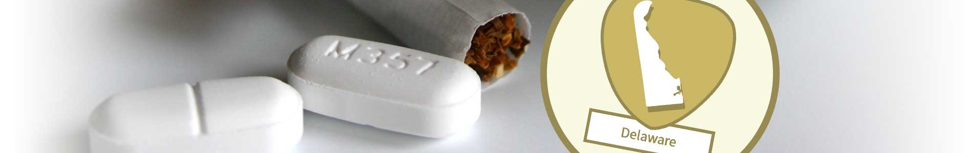 White pills and filter cigarettes laying on white surface for substance abuse and Delaware state outline