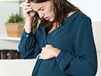 White pregnant lady in distress and preparing to seek medical help