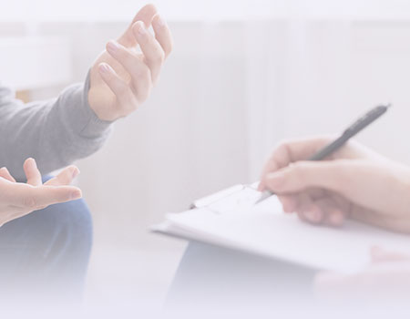 Hand writing on paper and set of other hands representing mental health nursing CEUs